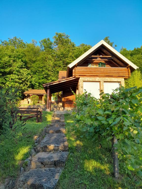 uma cabana de madeira com um caminho de pedra à sua frente em Vikendica Volar em Prijedor