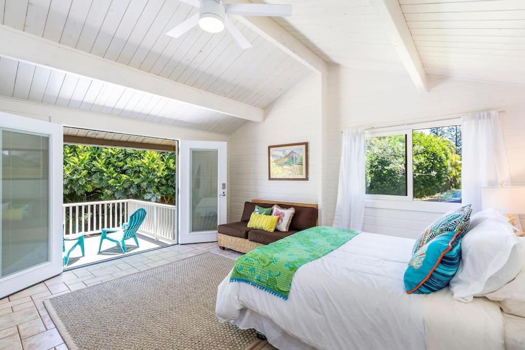 a bedroom with a large bed and a balcony at North Shore Garden Studio in Haleiwa