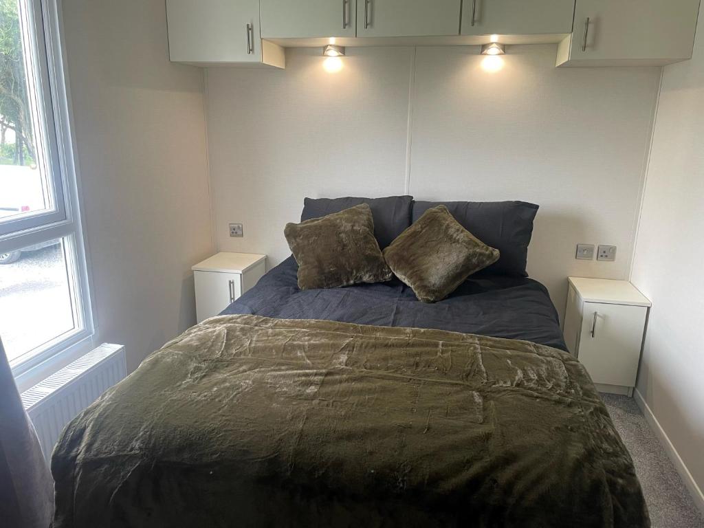 a bedroom with a bed with two pillows on it at 136, Port Haverigg in Millom