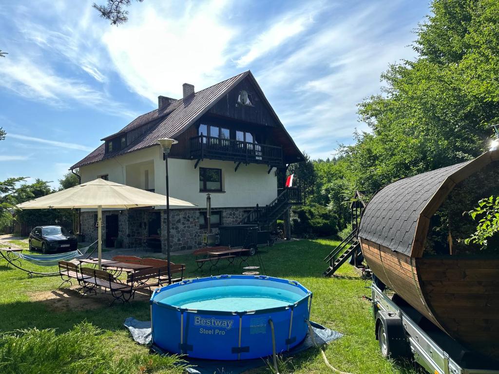 una casa con piscina nel cortile di Leśniczówka WIEŻYCA i Domki a Szymbark