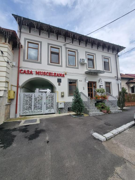 Biały budynek z znakiem na przedniej stronie w obiekcie Casa Musceleana w mieście Câmpulung
