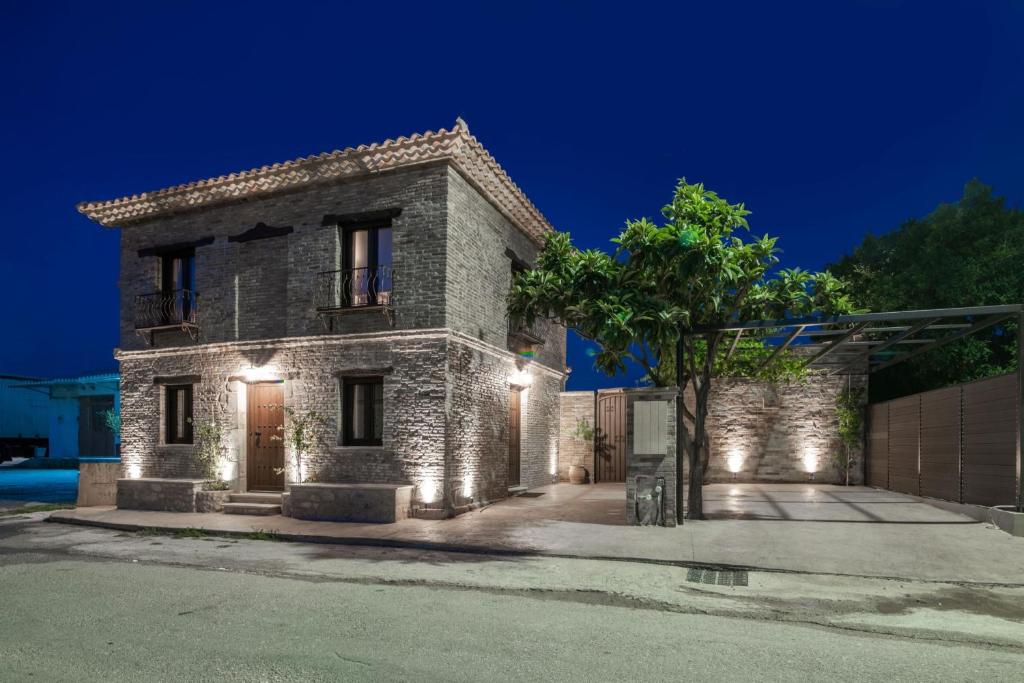 a stone house with lights on the front of it at Villa Frontale in Kallithea