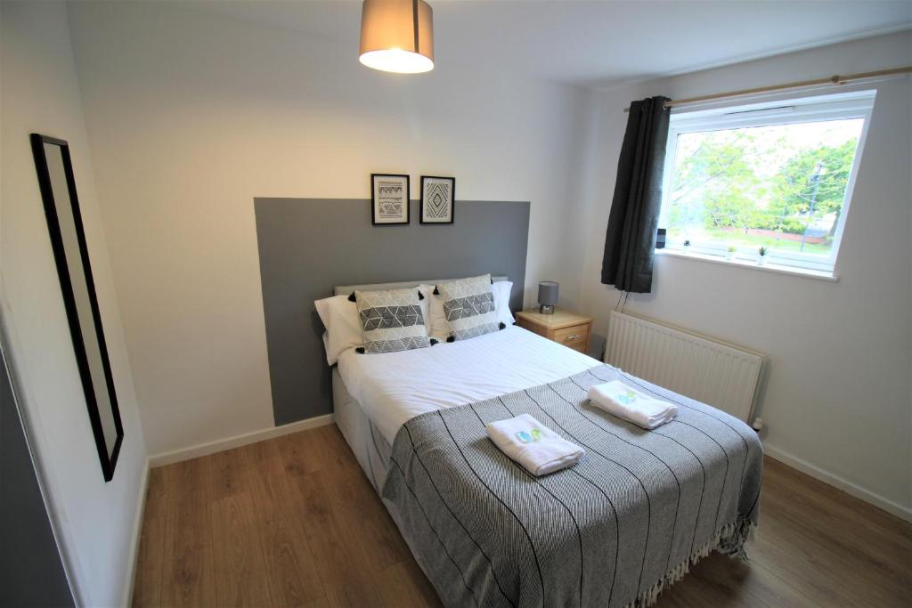 ein Schlafzimmer mit einem Bett mit zwei Handtüchern darauf in der Unterkunft Hamilton House -3 bed Close to Town, Drive Parking, 2 toilets in Newcastle upon Tyne