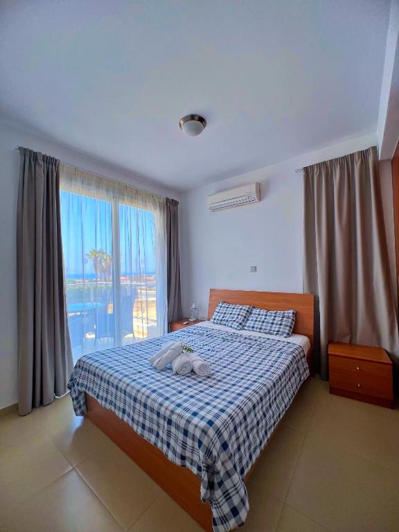 a bedroom with a bed with a blue and white blanket at 3 Bedroom Coral Bay Beach Seaview Villa I Private Pool in Peyia