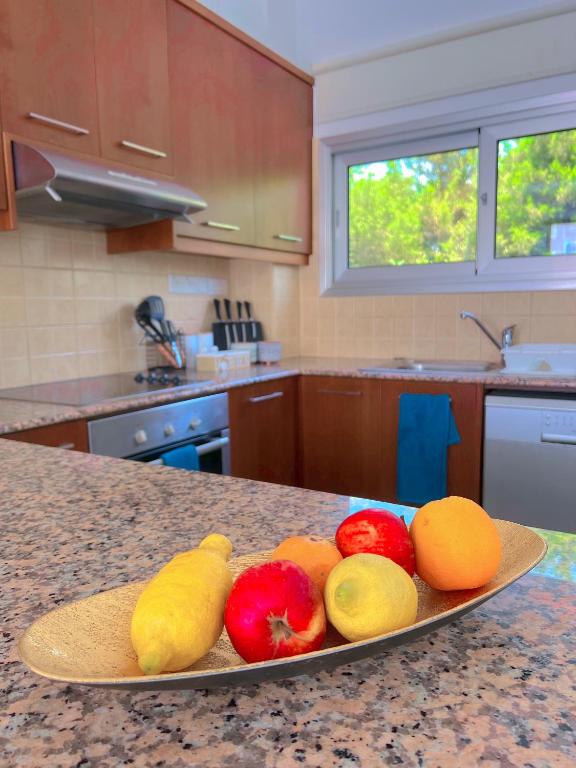 a plate of fruit on a counter in a kitchen at 3 Bedroom Coral Bay Beach Seaview Villa I Private Pool in Peyia