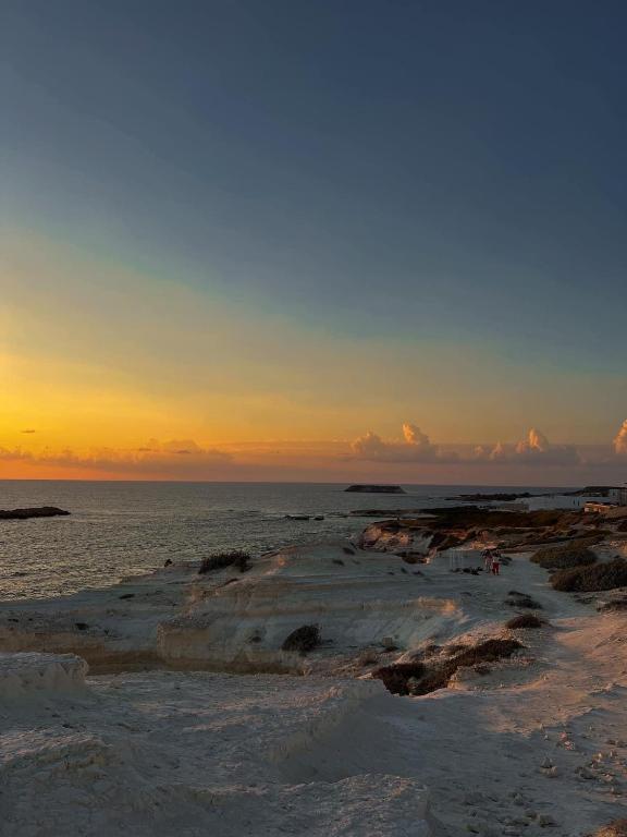 a beach with the sun setting in the ocean at 3 Bedroom Coral Bay Beach Seaview Villa I Private Pool in Peyia