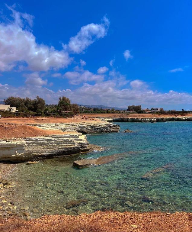 a beach with clear blue water and rocks at 3 Bedroom Coral Bay Beach Seaview Villa I Private Pool in Peyia