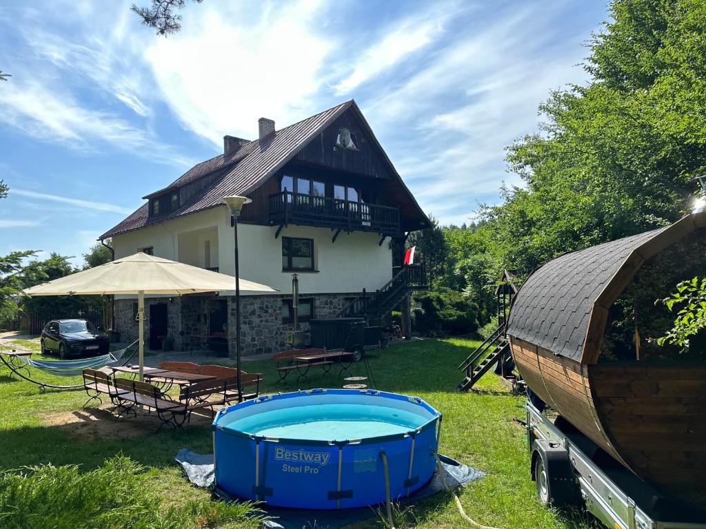 une maison avec une piscine dans la cour dans l'établissement Weekend house w lesie, na Kaszubach, à Rybaki