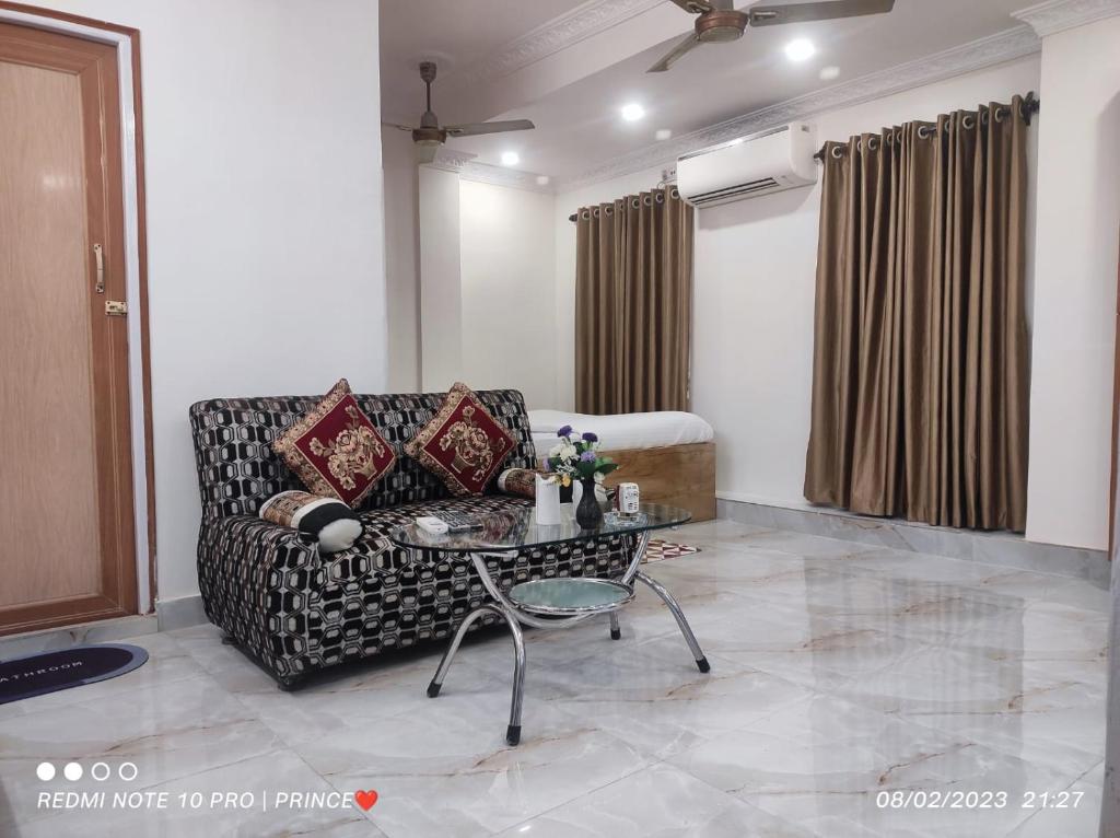 a living room with a couch and a table at Rose Premium Studio Apartment by Hotel Airways in Kolkata