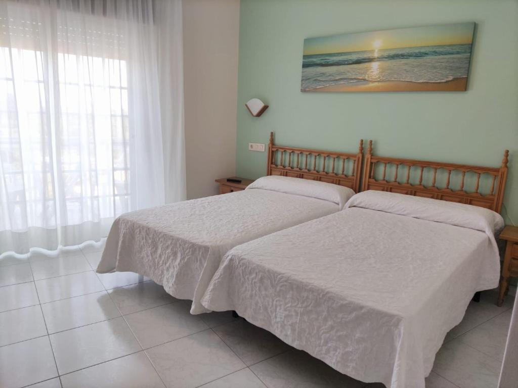 1 dormitorio con 2 camas y ventana en Hotel Bonaire, en A Revolta
