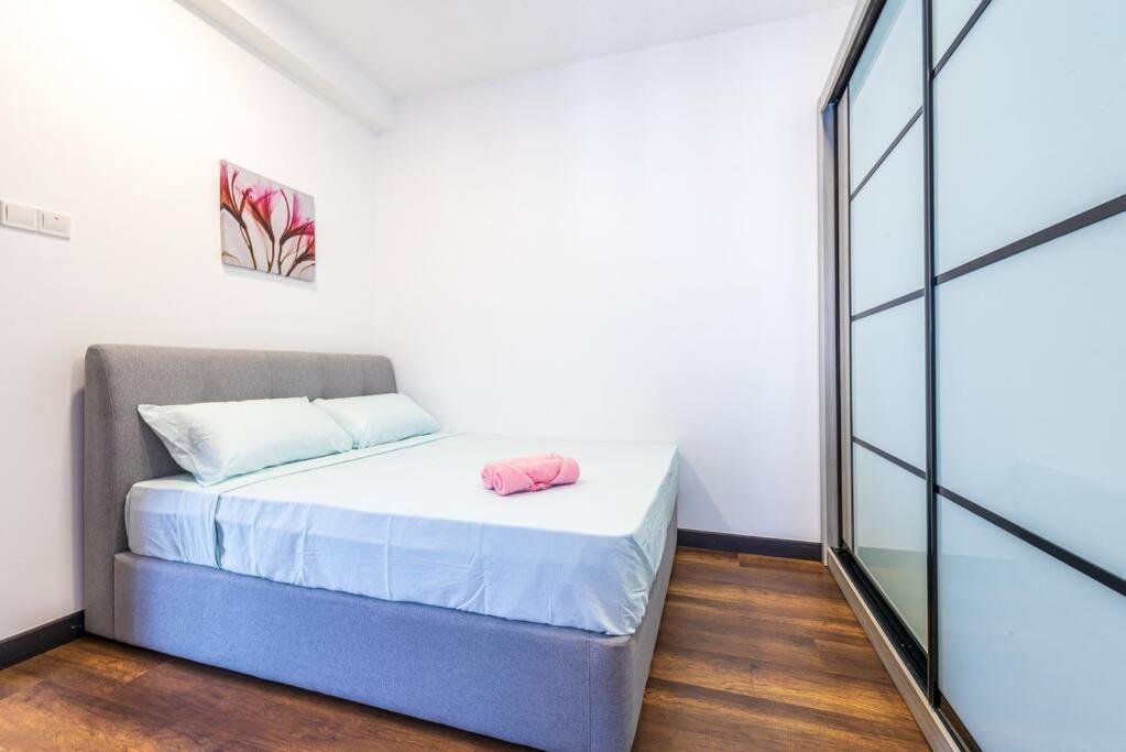 a small bedroom with a bed and a glass wall at Simfoni Tower 3R2B 8pax @C180@Chr Trader Square in Seri Kembangan