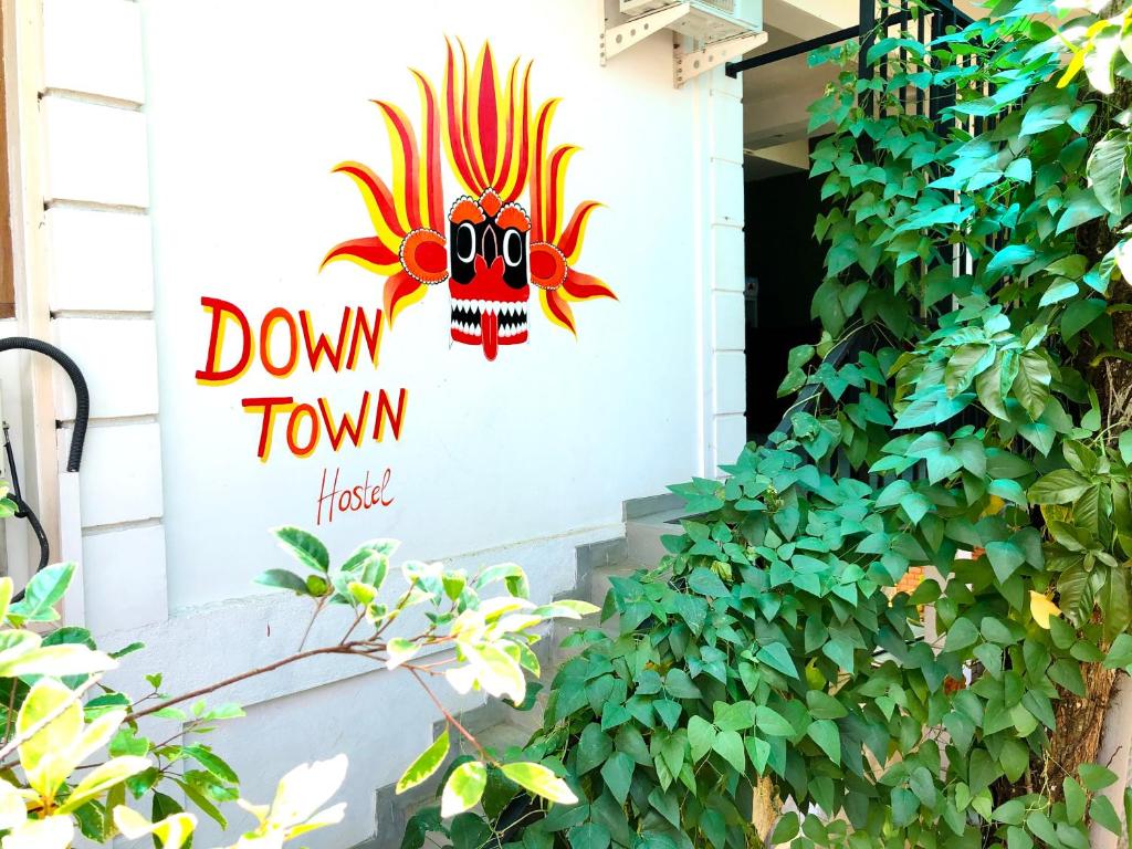 een bord dat zegt beneden de stad op een gebouw bij Downtown Hostel Ella in Ella