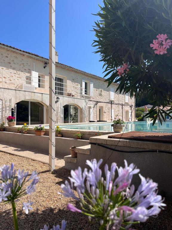 budynek z basenem i fioletowymi kwiatami w obiekcie Domaine Amourella w mieście Lambesc