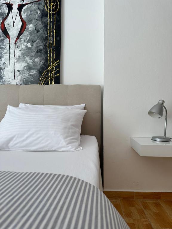 ein Schlafzimmer mit einem Bett, einer Lampe und einem Bild in der Unterkunft Piazza in Dubrovnik