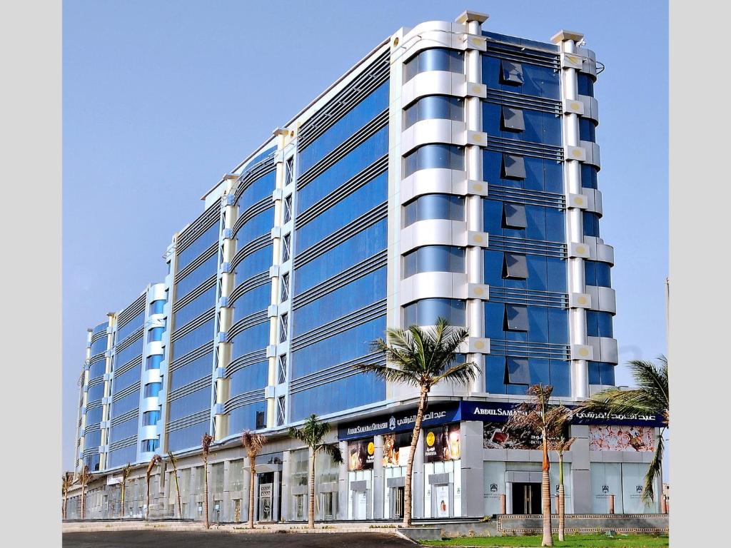 un alto edificio azul con palmeras delante en Spectrums Al Salamah Jeddah, en Yeda