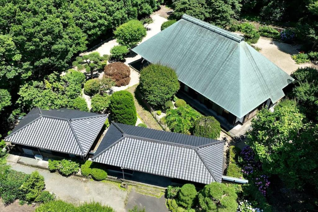 une vue sur une maison avec deux toits dans l'établissement 甘糟屋敷 Amakasu Yashiki KAMAKURA, à Kamakura