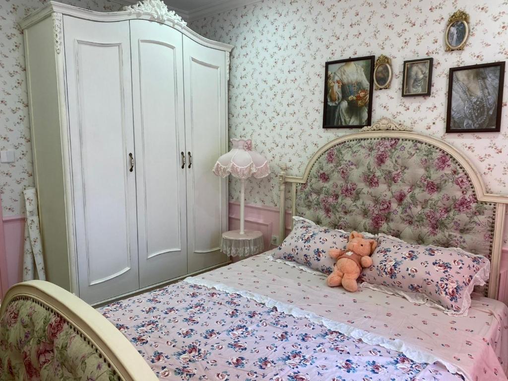 a bedroom with a bed with a teddy bear on it at Princess Vinhomes Smart City Apartment in Hanoi