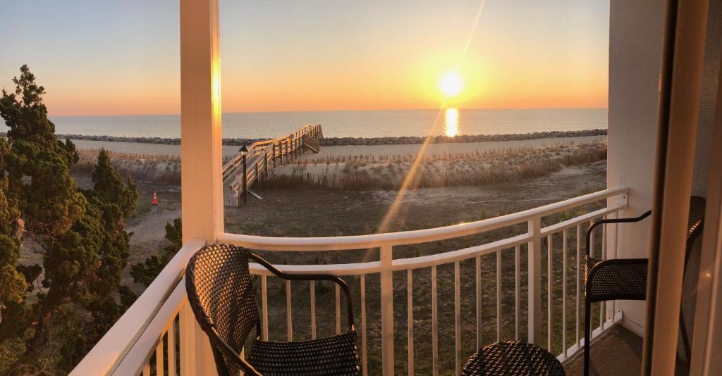 a balcony with a view of the ocean at sunset at VILLA 176 - Villa Delmar condo in Jekyll Island