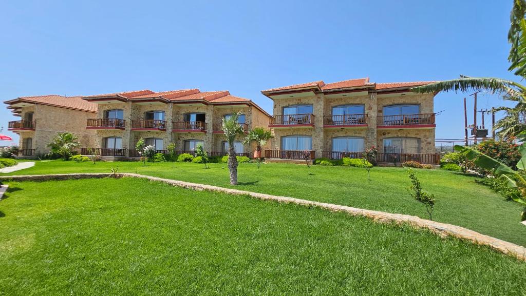 a large house with a lawn in front of it at BURHAN'S HOTEL in Rizokarpaso