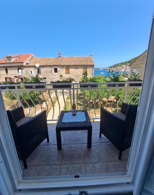 a balcony with a table and two chairs and a view at Apartman Prošperino in Vis