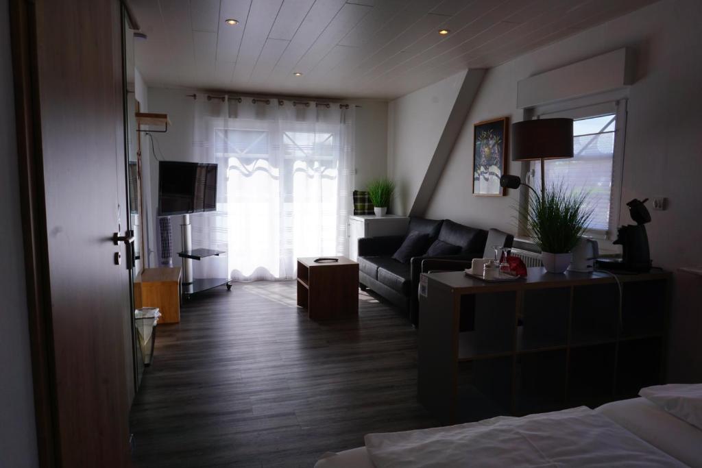 a living room with a bed and a couch at Pension Julia 2 in Norden