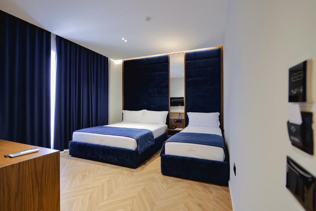 a hotel room with two beds and a desk at Duka's Hotel in Ksamil