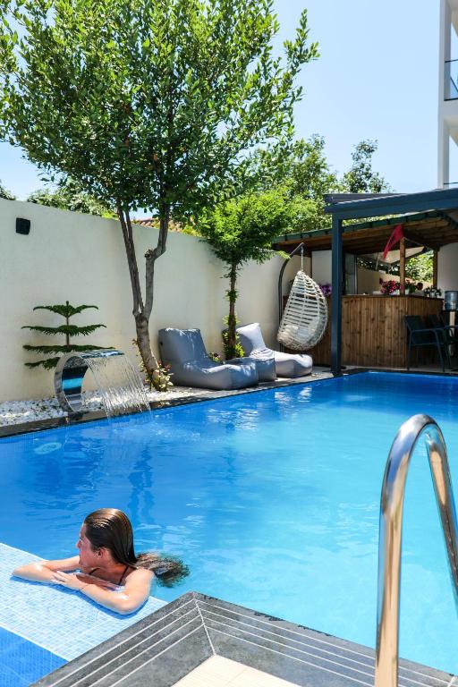 a woman laying in a swimming pool at Duka's Hotel in Ksamil