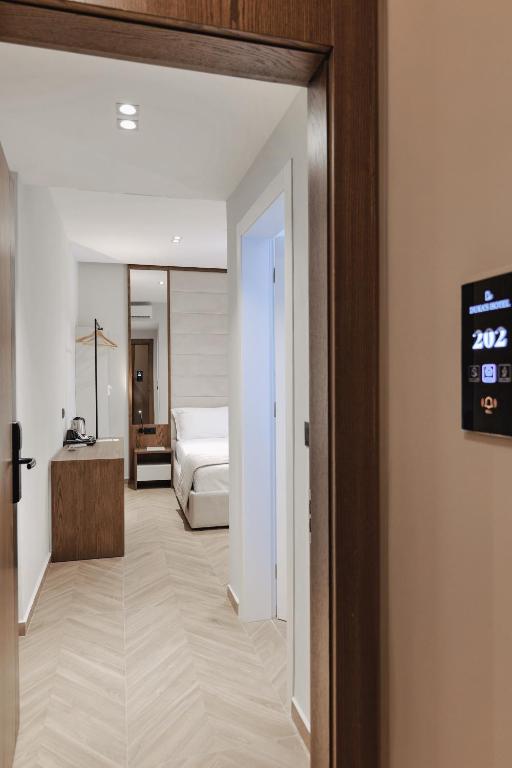 a hotel room with a bed and a clock on the wall at Duka's Hotel in Ksamil