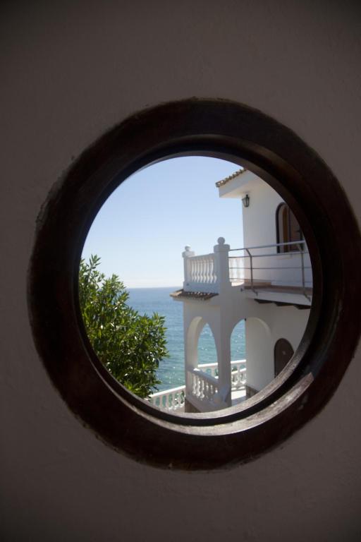 a view of a building through a circular window at Hostal Mar de Frente in Los Caños de Meca