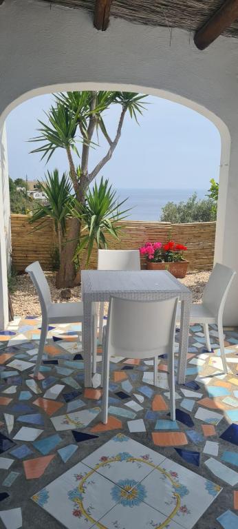 a white table and chairs on a mosaic floor at Casa Colomba Sant'Angelo in Sant'Angelo D'Ischia