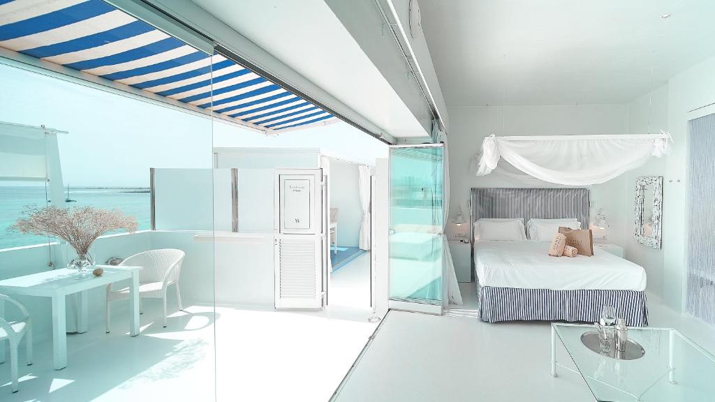 a white bedroom with a bed and a desk and a table at AVANTI Lifestyle Hotel - Only Adults in Corralejo