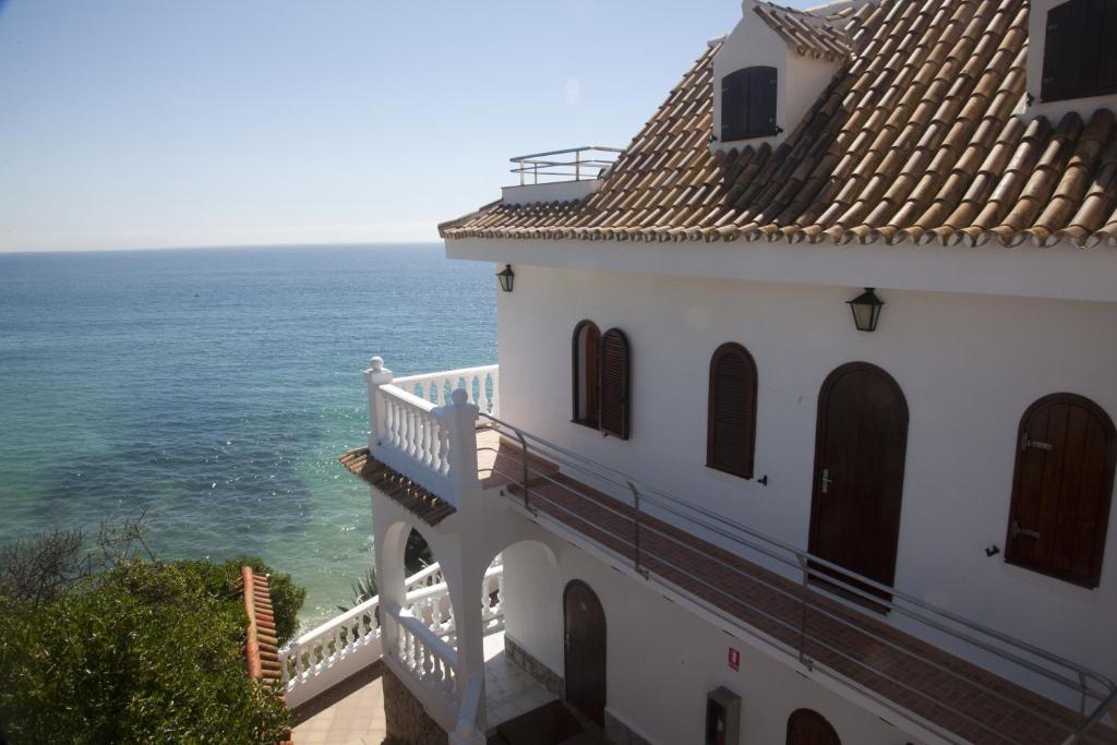 a building with a balcony overlooking the ocean at Hostal Mar de Frente in Los Caños de Meca