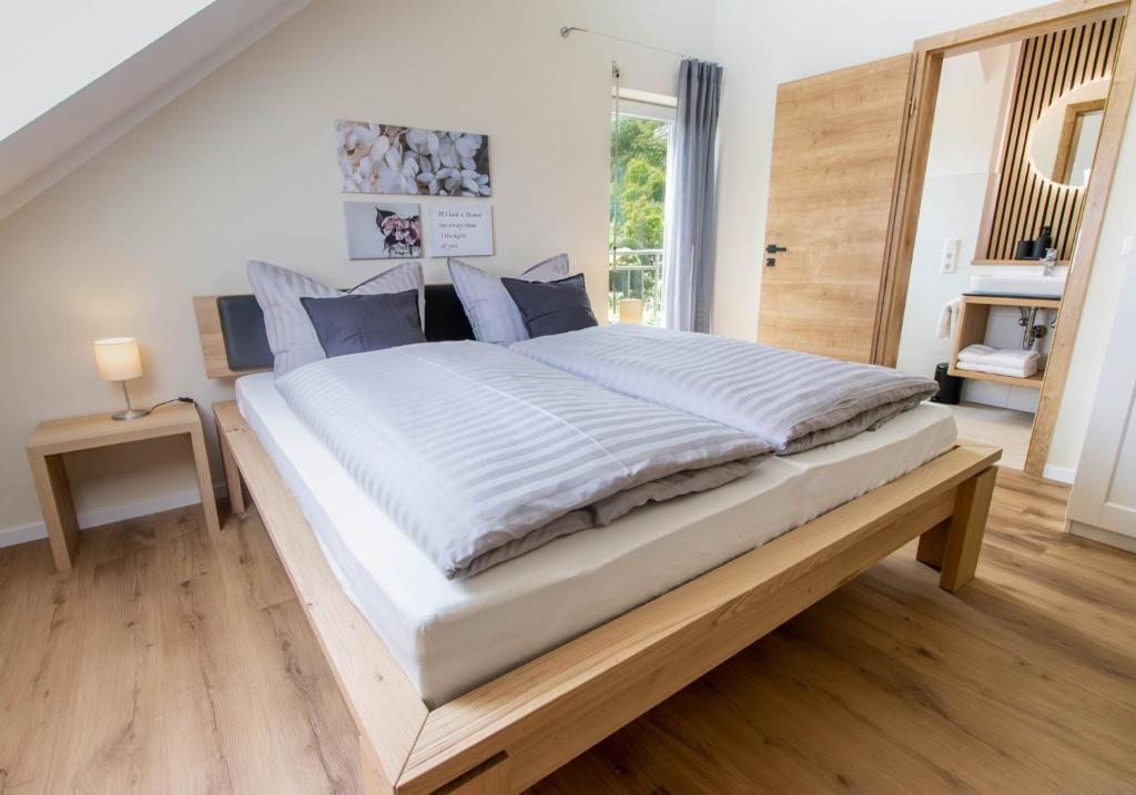 a large bed in a bedroom with a wooden floor at Ferienhaus Moselhöhe - 2023 neu renoviert, mit Design-Ausstattung & großem Garten in Traben-Trarbach