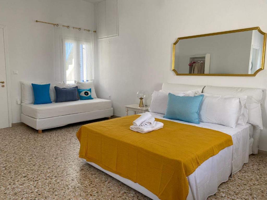 a bedroom with a large bed with a yellow blanket at Octopus Suites Parikia in Parikia