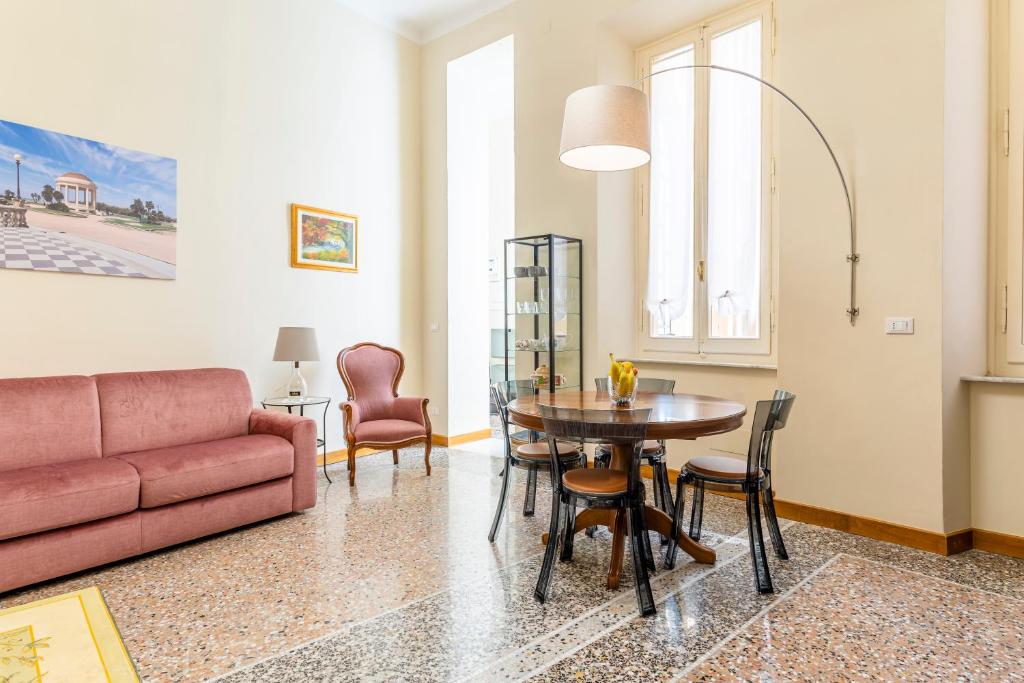 uma sala de estar com um sofá, uma mesa e cadeiras em Livorno Central Flat-2 min walk the Cathedral! em Livorno