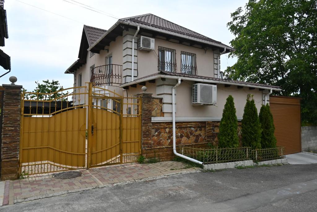 a yellow fence in front of a house at Bright and cozy home with personal terrace in Chişinău