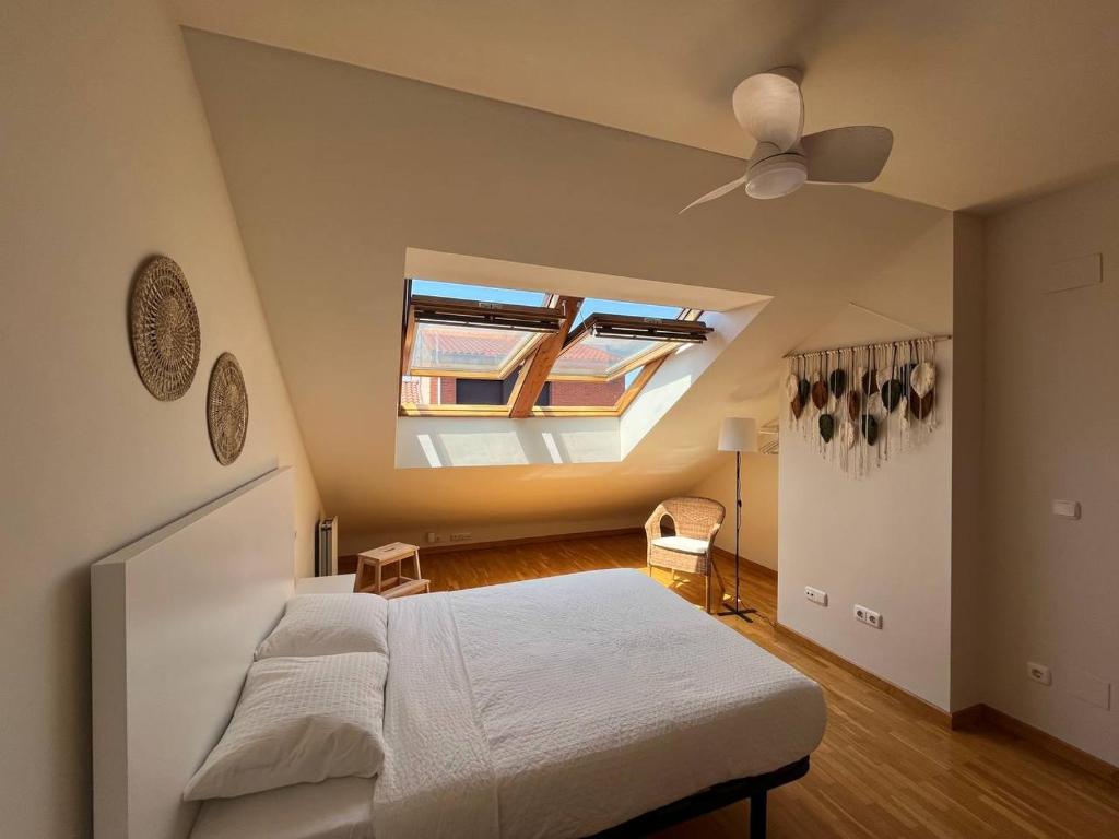 a bedroom with a bed and a ceiling fan at Dúplex Calle Cuba Gijón in Gijón