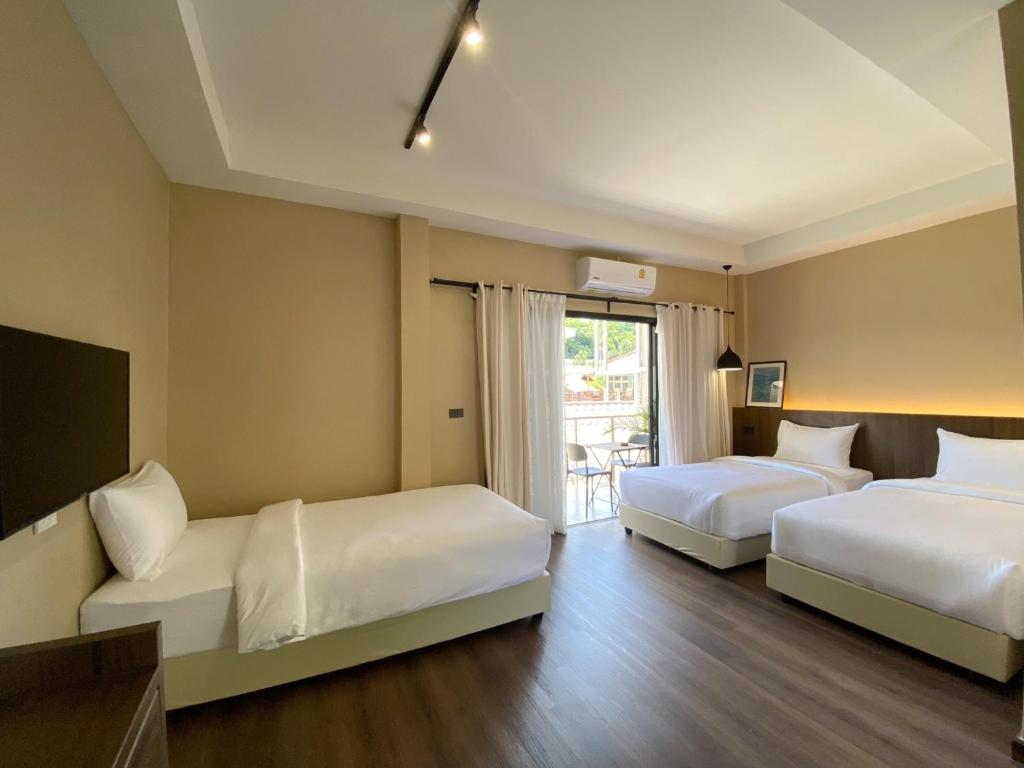 a hotel room with two beds and a window at Suncloud Hotel Koh Samet in Ko Samed