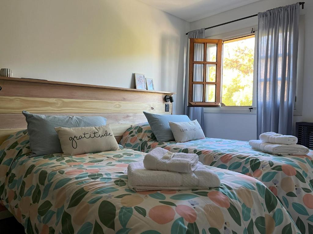 1 dormitorio con 2 camas y toallas. en Alto Atardecer en San Martín de los Andes