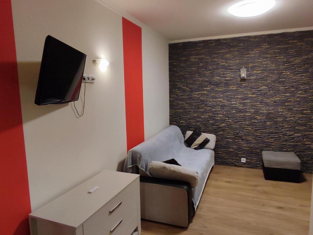 een woonkamer met een bank en een tv aan de muur bij Apartment in the center of Krakow in Krakau