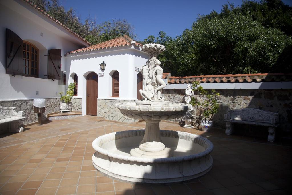 a fountain in a courtyard in front of a house at Hostal Mar de Frente in Los Caños de Meca