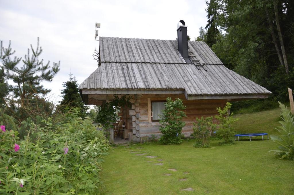 a log cabin with a slate roof in a yard at Mountain chalet SmoLenisko domek w górach in Nowy Targ
