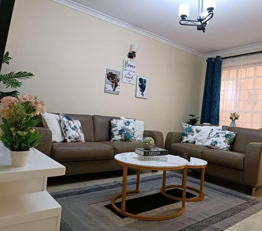 a living room with a couch and a coffee table at Lux Suites Neema court Apartments in Nairobi