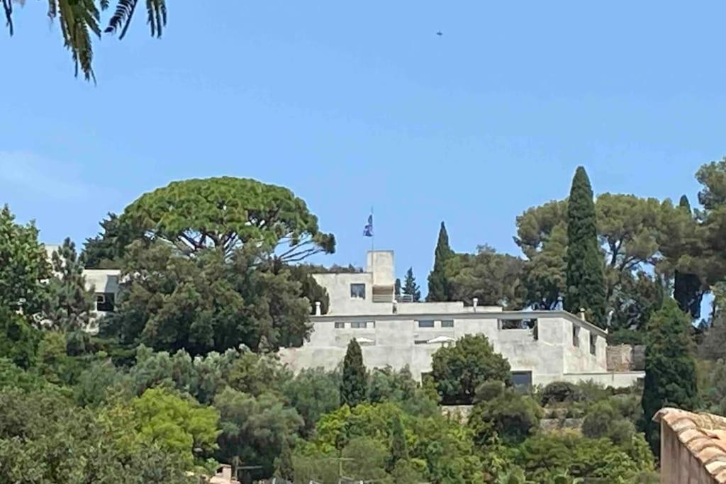 una gran casa blanca en una colina con árboles en Loft apartment at Villa Leonie en Hyères