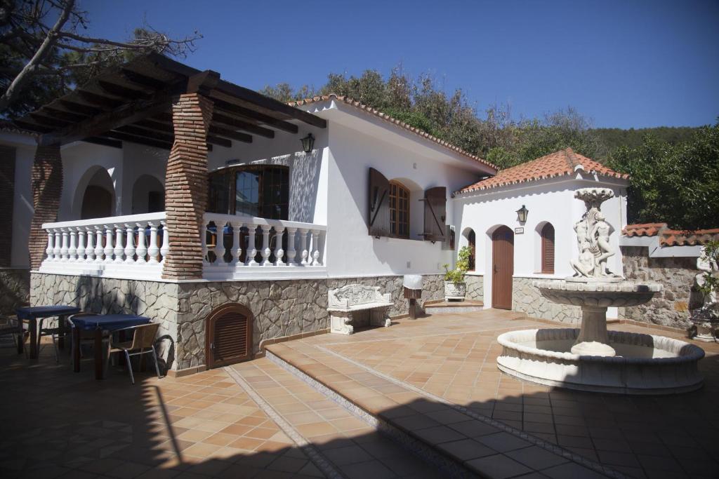 a house with a courtyard with a fountain in front of it at Hostal Mar de Frente in Los Caños de Meca