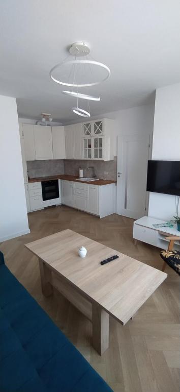 ein Wohnzimmer mit einem Holztisch in der Mitte in der Unterkunft Apartament Kopernika in Nowe Miasto Lubawskie