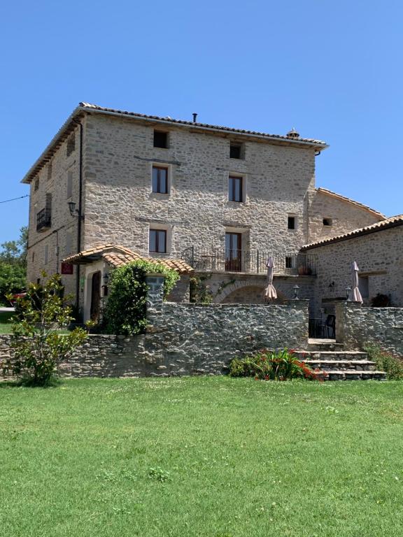 um grande edifício de pedra com escadas e um quintal relvado em Casa Lascorz em La Pardina