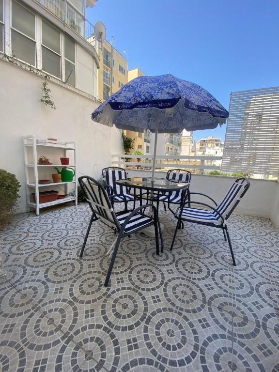 a table and chairs with an umbrella on a balcony at INANNA HOME in Bari