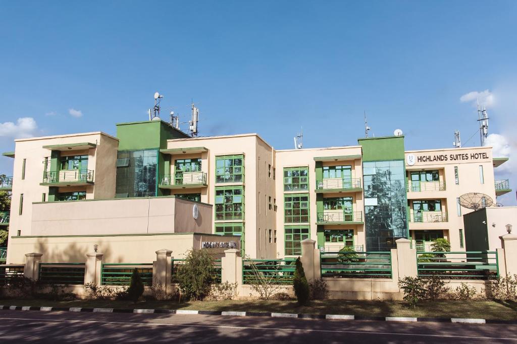 an apartment building with a sign in front of it at Highlands Suites Hotel and Apartments in Kigali