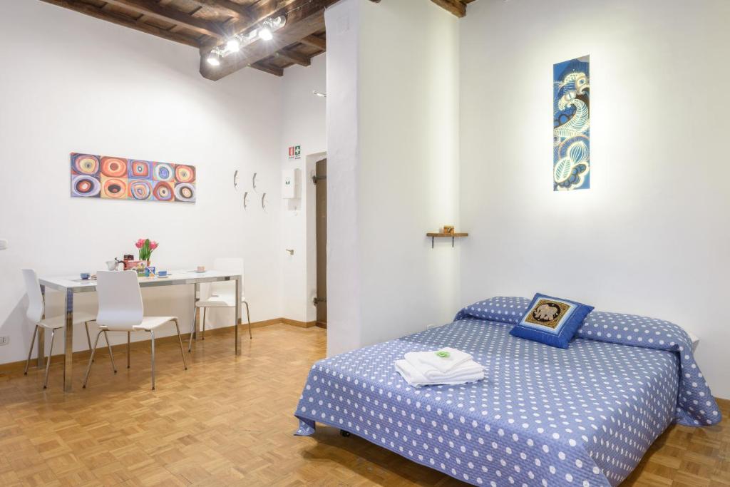 ローマにあるCasa Tua a Montiのベッドルーム1室(ベッド1台、テーブル、椅子付)